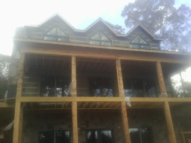 Dormers and porch framing on a large log home under construction — Roof Coating work by our crew in Pleasant Prairie