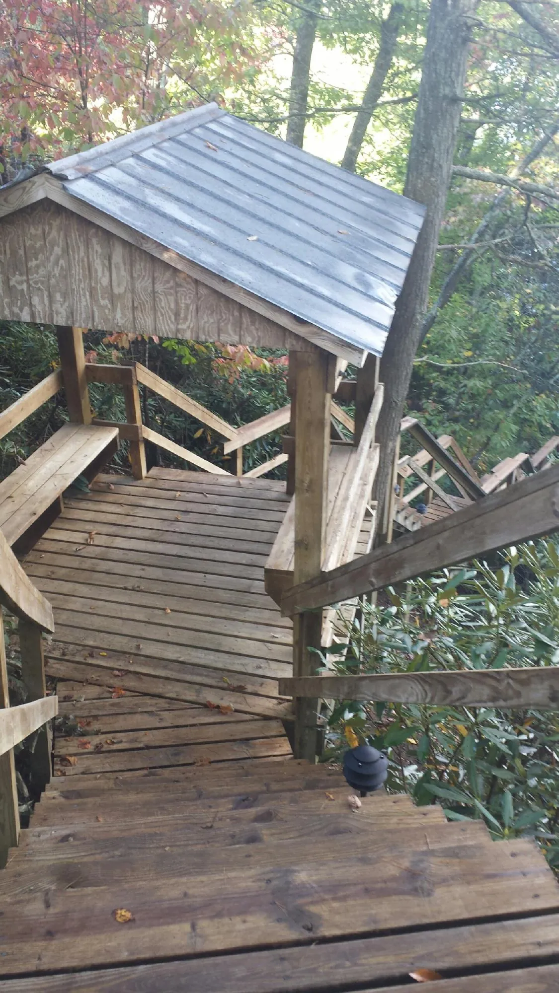 Metal roofed shelter over wooden steps on a wooded walkway — Skylight Repair & Installation work by our crew in Pleasant Prairie