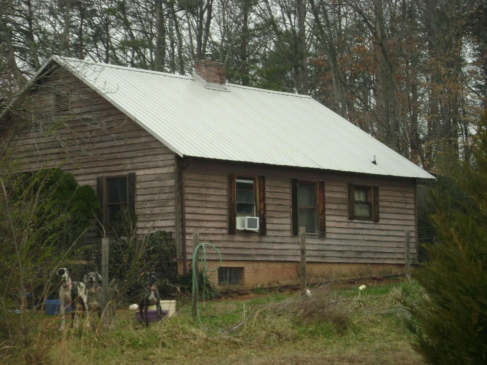 White metal roof on an old wood sided farmhouse, from a Metal Roof Installation job in Pleasant Prairie
